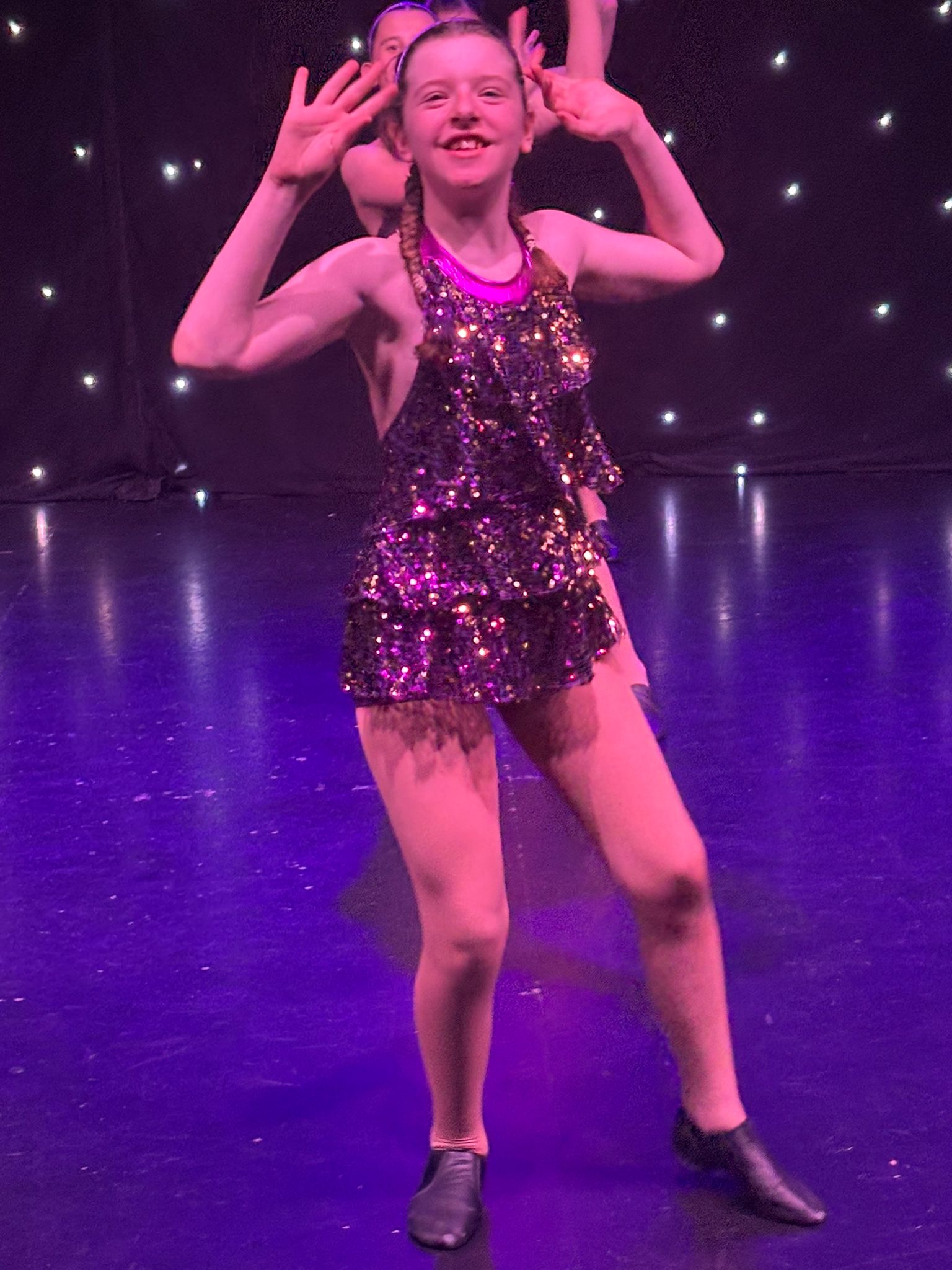 Tap dance students performing synchronized routine on stage